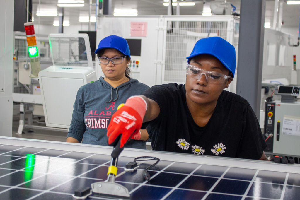 Runergy Alabama production team makes adjustment to solar panel.